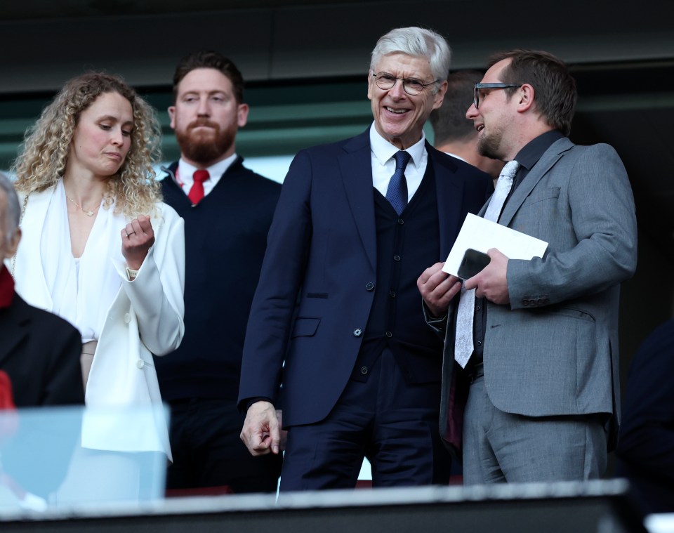 Arsene Wenger in the stands at a soccer match.