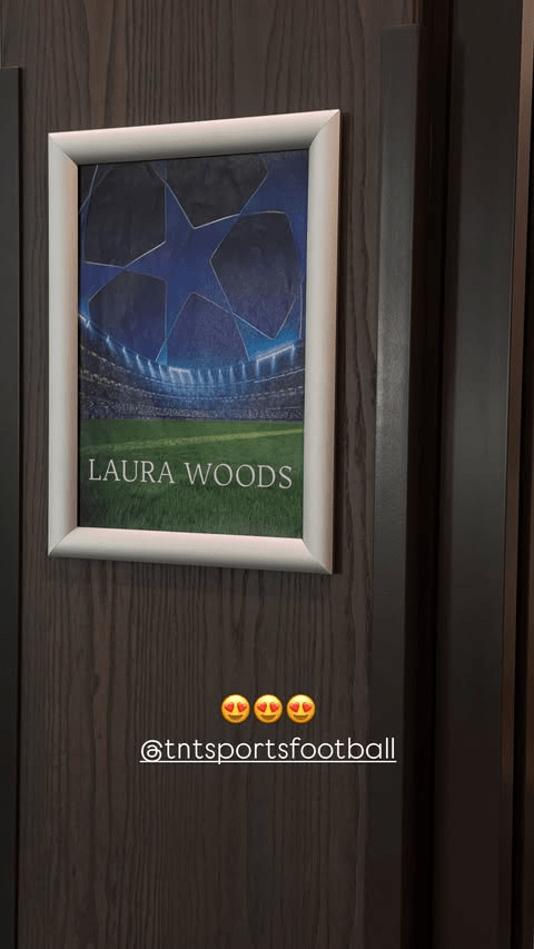Framed photo of a soccer stadium with Laura Woods' name below it.