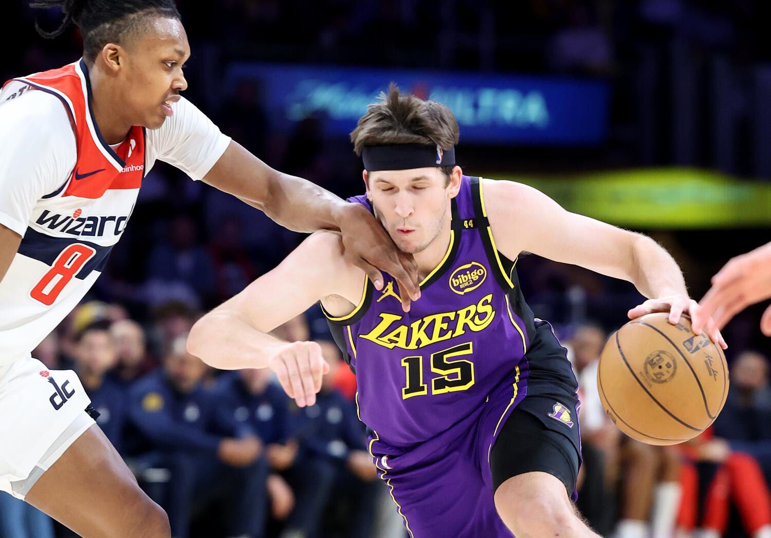 Lakers guard Austin Reaves, right, drives past Wizards guard Bob Carrington, left, during a game at Crypto.com Arena.