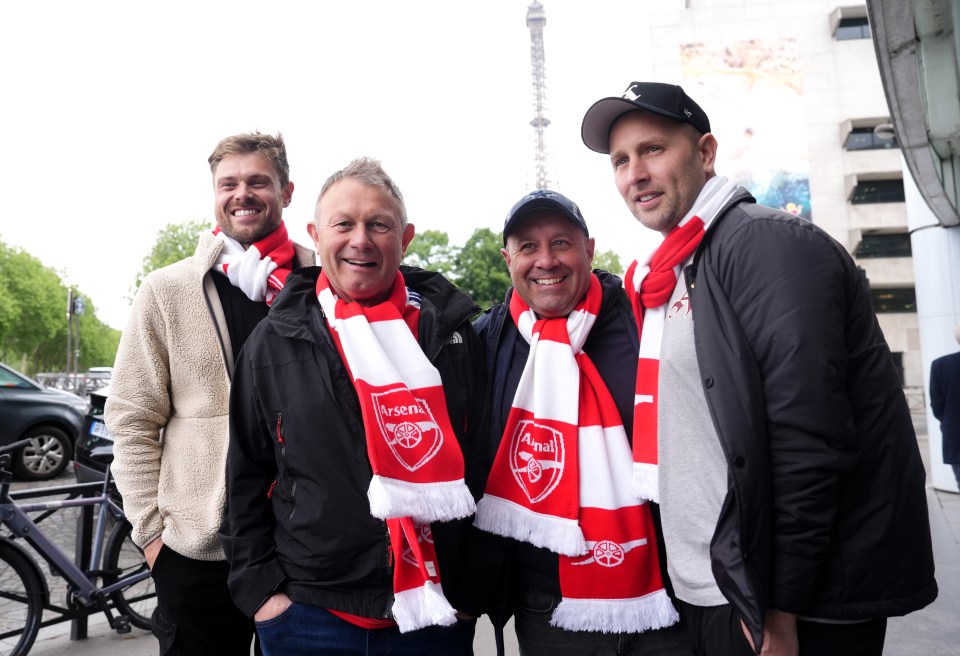 Four Arsenal fans in Paris wearing team scarves.
