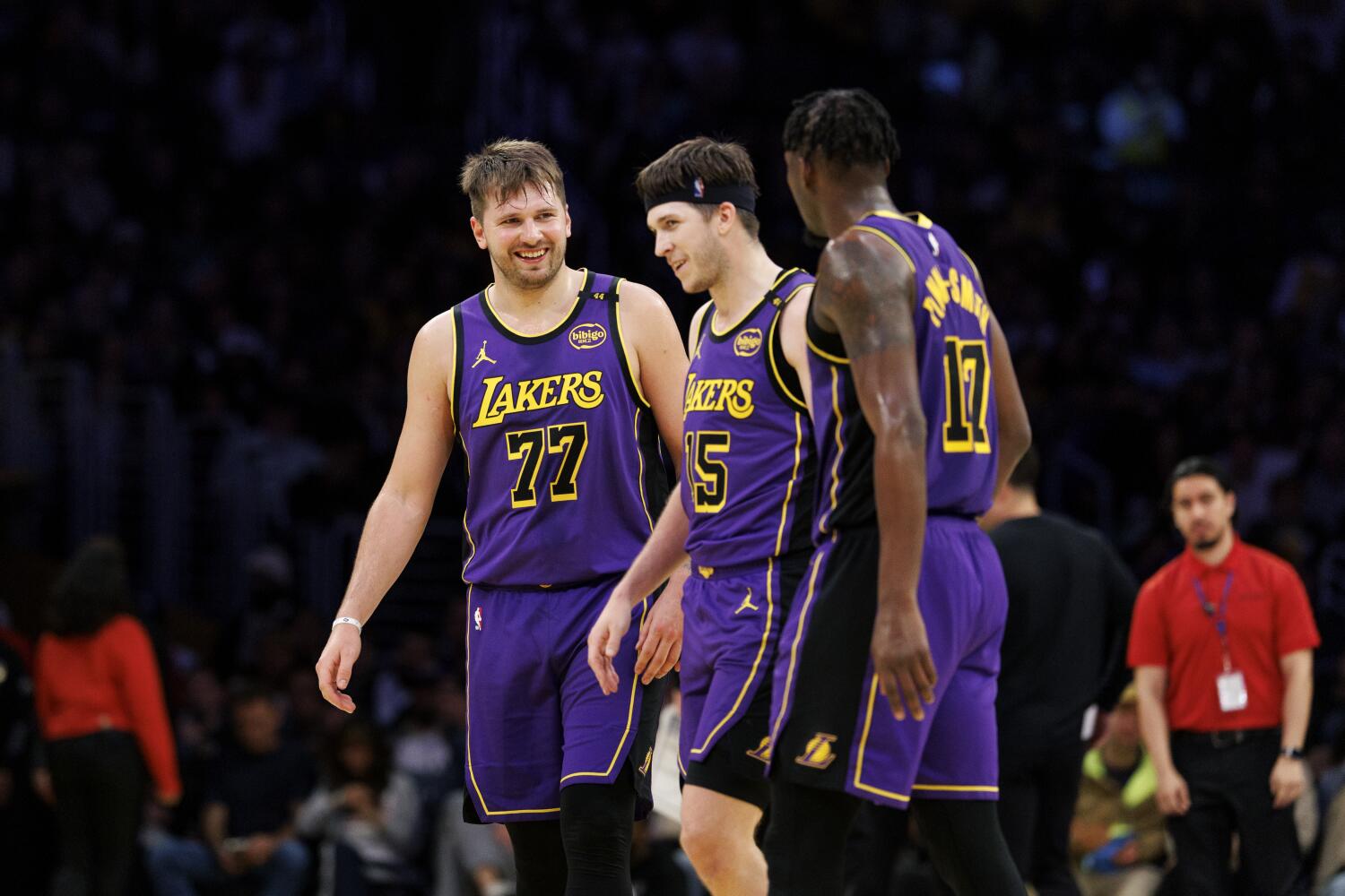 Luka Doncic, left, walks off the court during a timeout with Laker teammates Austin Reaves, center, and Dorian Finney-Smith.