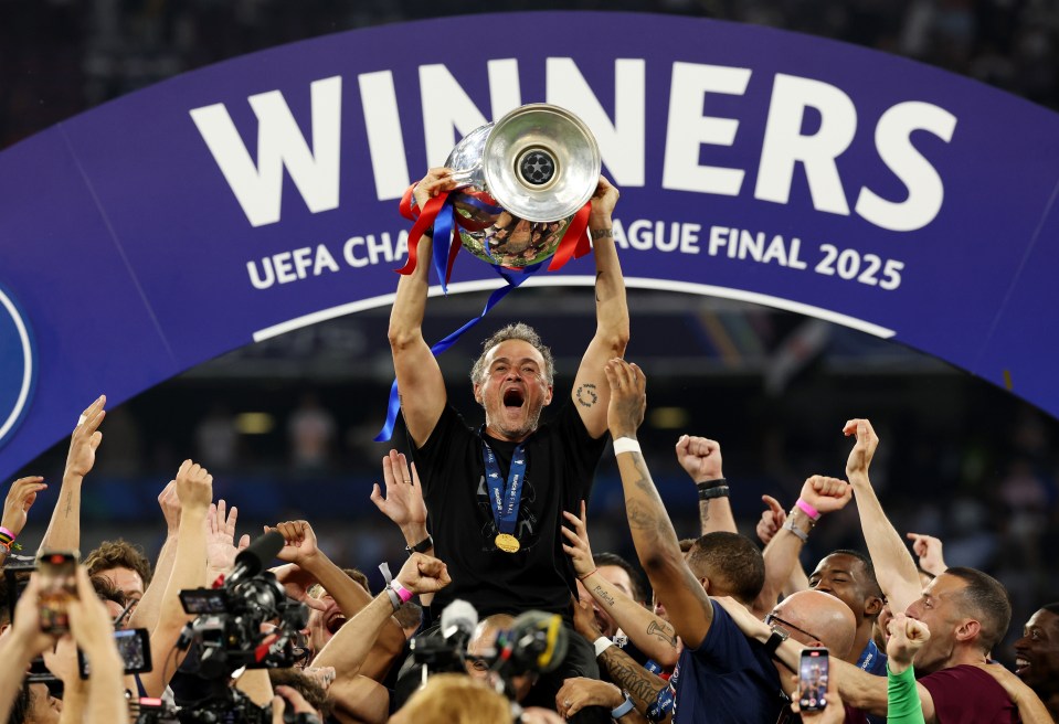 Luis Enrique, Paris Saint-Germain's head coach, lifts the UEFA Champions League trophy.