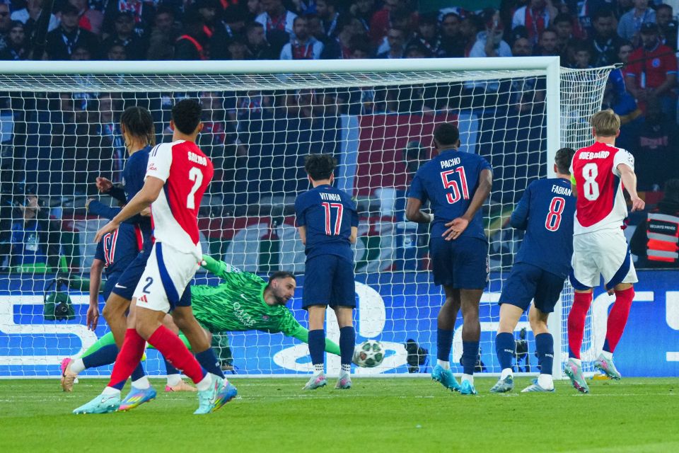 Martin Ødegaard of Arsenal shoots at goal, with the PSG goalkeeper making a save.