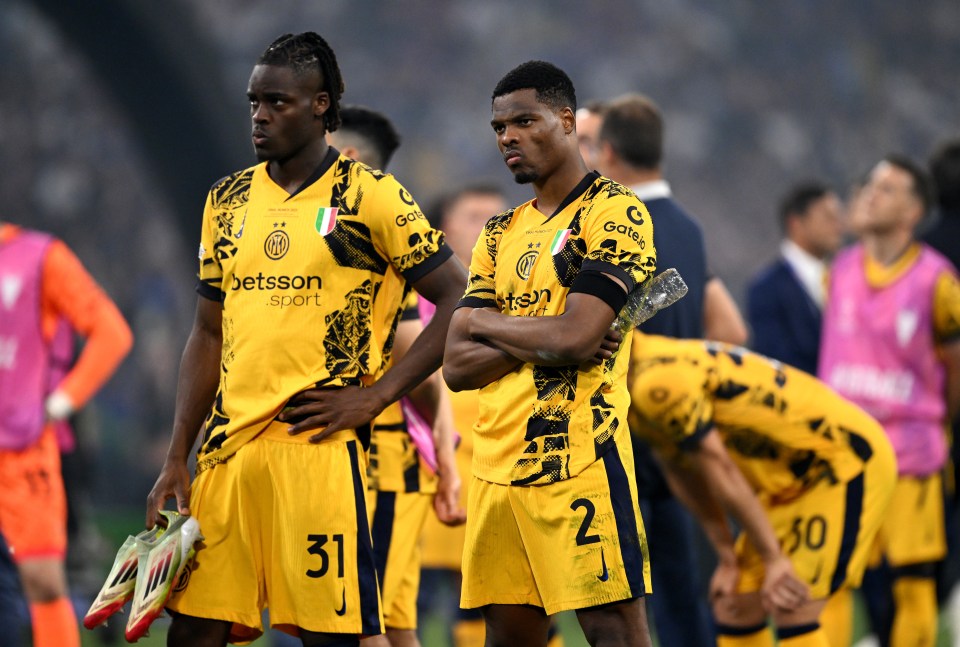 Yann Aurel Bisseck and Denzel Dumfries of FC Internazionale looking dejected after a Champions League final loss.