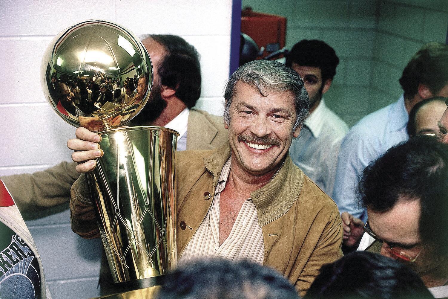 Lakers owner Jerry Buss celebrates with the Larry O'Brien Trophy after the team's 1980 NBA championship victory.
